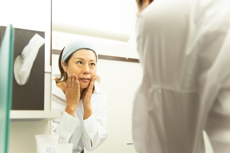 鏡の前で肝斑を気にする女性